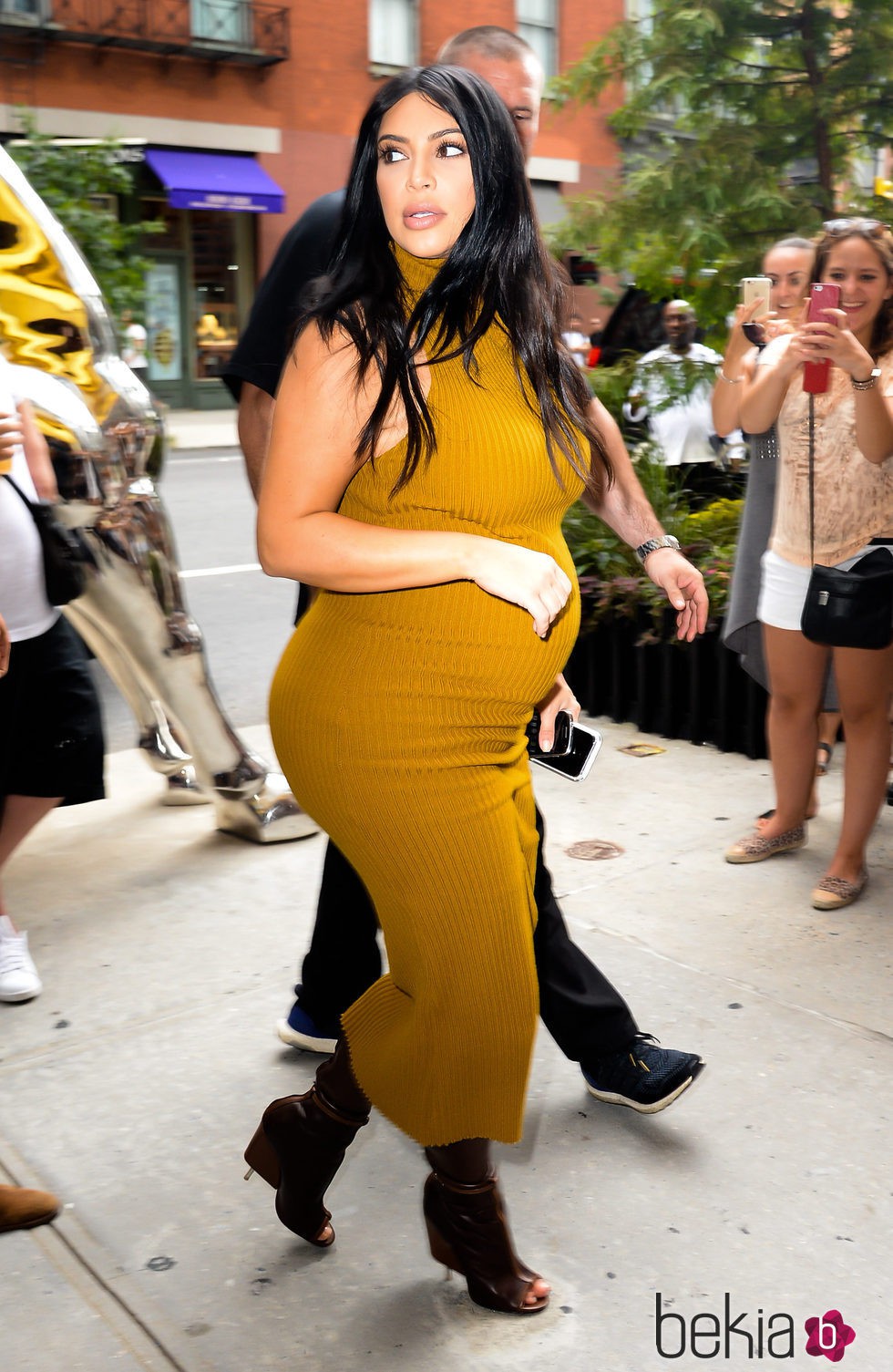 Kim Kardashian con vestido largo mostaza en su segundo embarazo