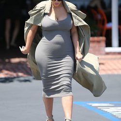 Kim Kardashian con vestido gris y gabardina en su segundo embarazo