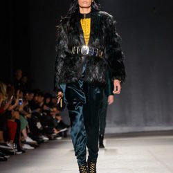Modelo con abrigo negro y pantalón azulado en el desfile de Balmain para H&M en Nueva York