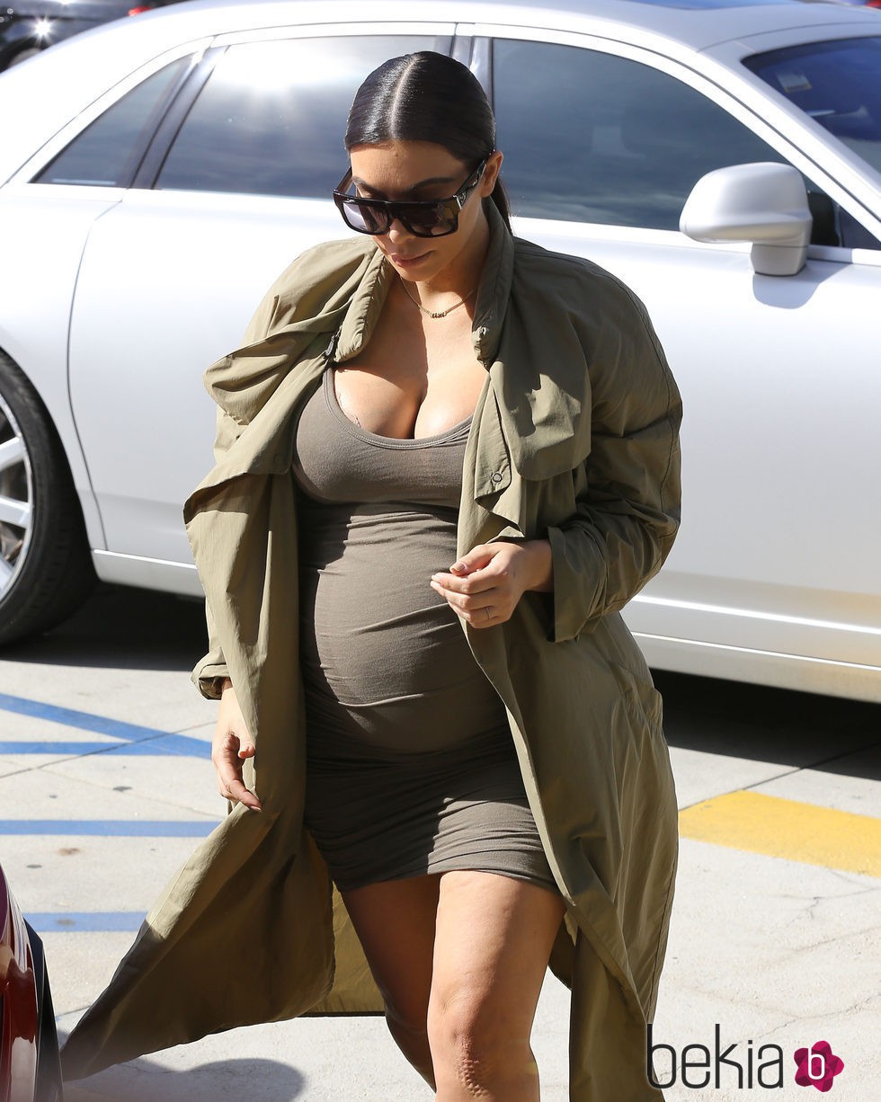 Kim Kardashian con mini vestido y gabardina caqui en su segundo embarazo