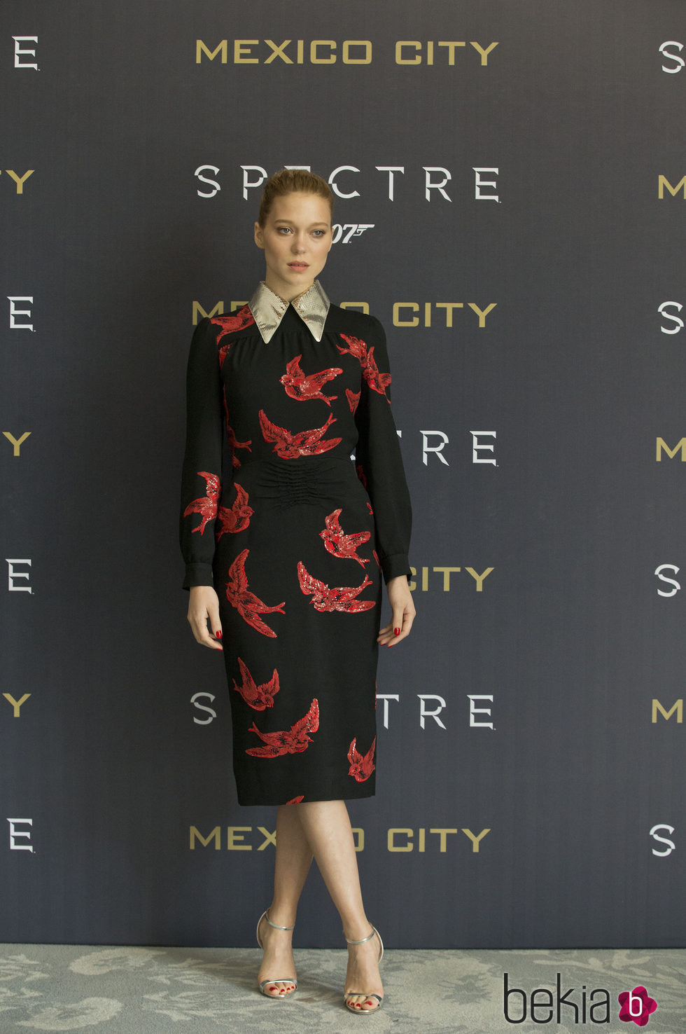 Lea Seydoux con vestido midi negro con motivos de pájaros rojos en el photocall de la premiere de 'Spectre' en Méjico