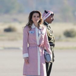 Rania de Jordania con abrigo en tweed y vestido azul en su llegada al aeropuerto de Madrid
