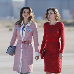 Rania de Jordania con abrigo en tweed y la Reina Letizia con vestido rojo de Felipe Varela en la llegada de Rania al aeropuerto de Madrid