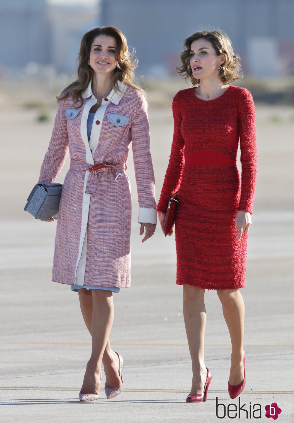 Rania de Jordania con abrigo en tweed y la Reina Letizia con vestido rojo de Felipe Varela en la llegada de Rania al aeropuerto de Madrid
