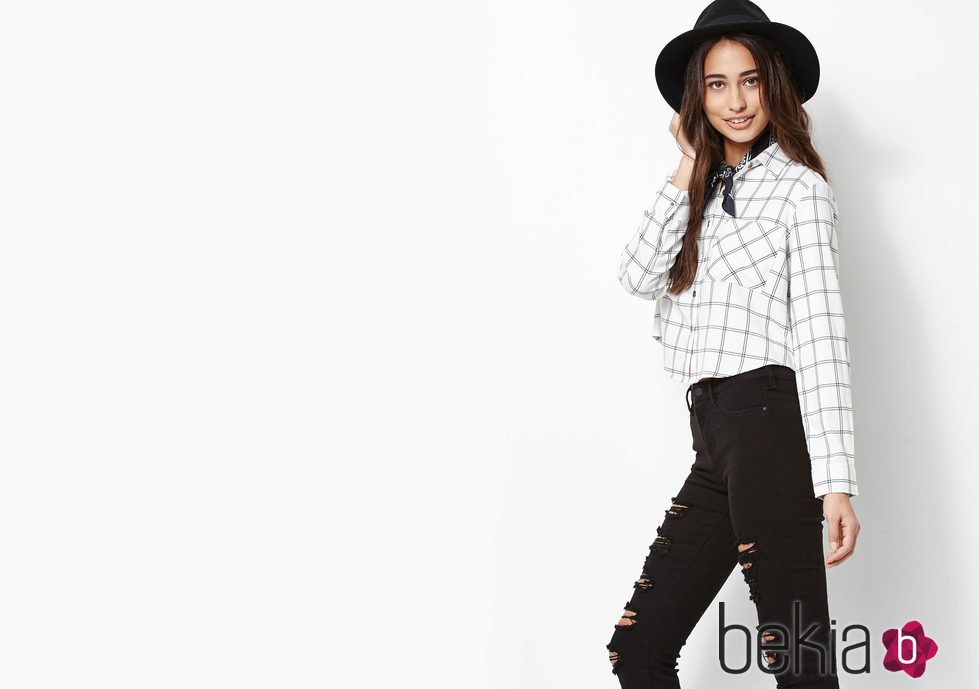 Modelo con blusa de cuadros y pantalones rotos con sombrero de Kendall y Kylie Jenner para PacSun