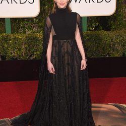 Emilia Clarke con vestido largo negro con transparencias y capa de Valentino