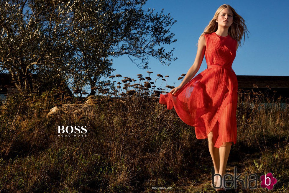 Anna Ewers con vestido vaporoso en naranja rojizo de Hugo Boss