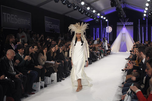 Vestido largo blanco de estilo túnica con tocado de plumas blancas en el desfile de David Christian en la Madrid Fashion Show 2016