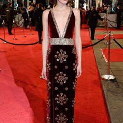 Stacy Martin con un modelo de terciopelo rojo con detalles brillantes en la alfombra roja de los BAFTA 2016
