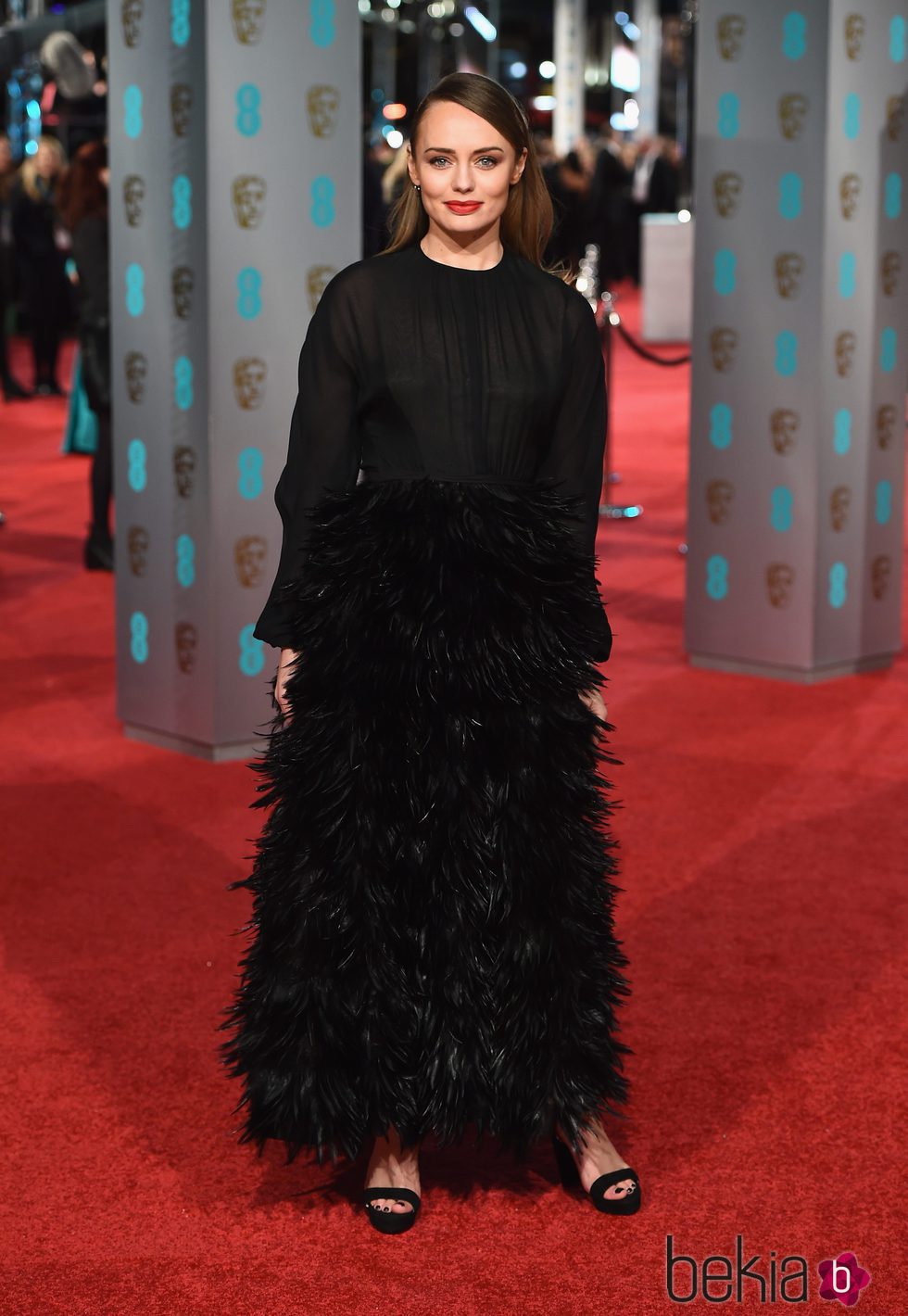 Laura Haddock con un diseño total black de plumas en la alfombra roja de los BAFTA 2016
