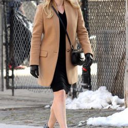 Kate Winslet con abrigo marrón y vestido negro más complementos