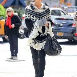 Kate Beckinsale con poncho tejido, pantalón y botines negros