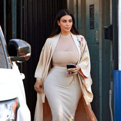 Kim Kardashian con blusa de transparencias, falda señida y abrigo tipo kimono