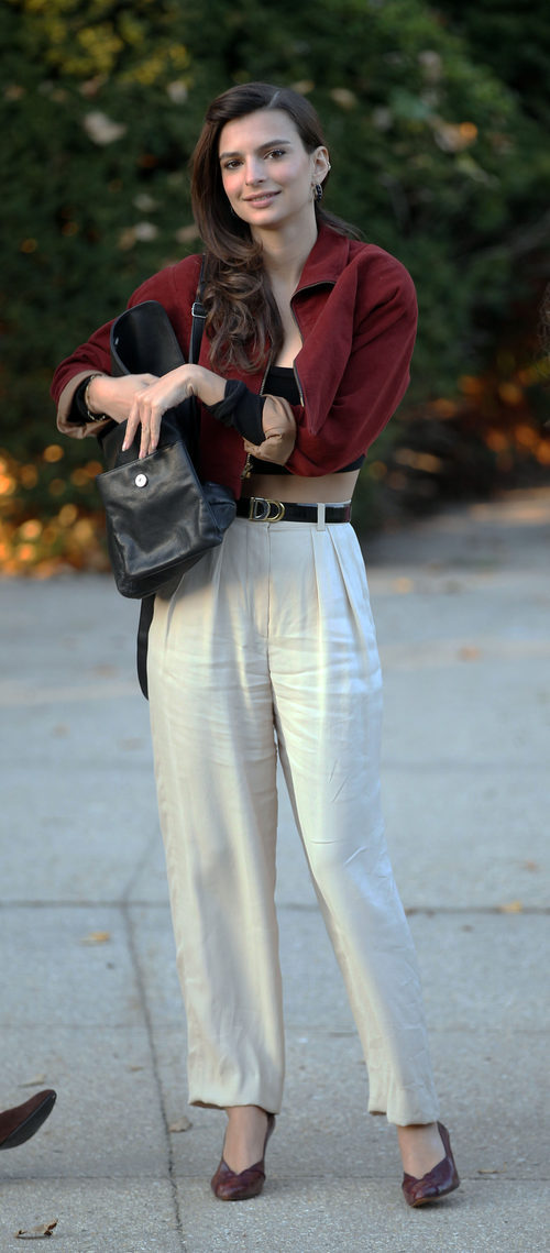 Emily Ratajkowski con conjunto de pantalón talle alto blanco y bomber granate