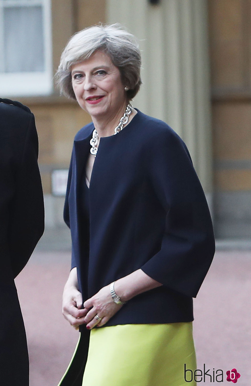 Theresa May con un total look formal con abrigo bicolor