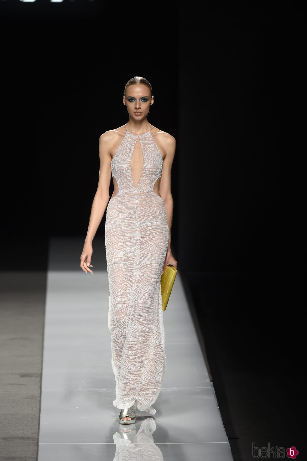 Vestido largo gris transparente con cartera amarilla y zapatos plateados de Felipe Varela colección primavera/verano 2017 en la Madrid Fashion Week
