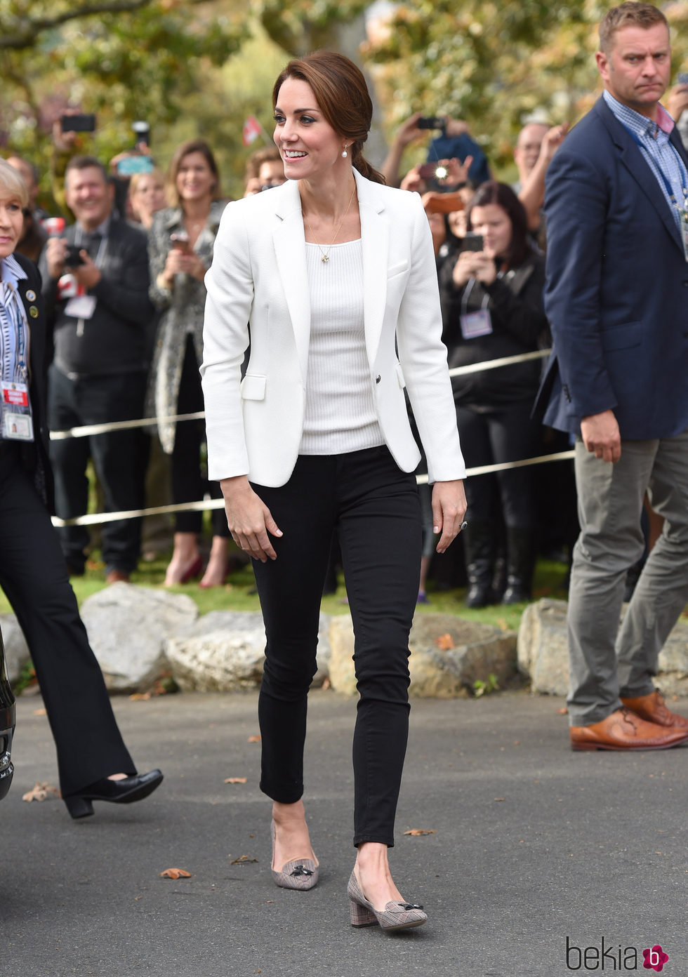 Kate Middleton con pantalón negro y americana blanca en su viaje a Canadá